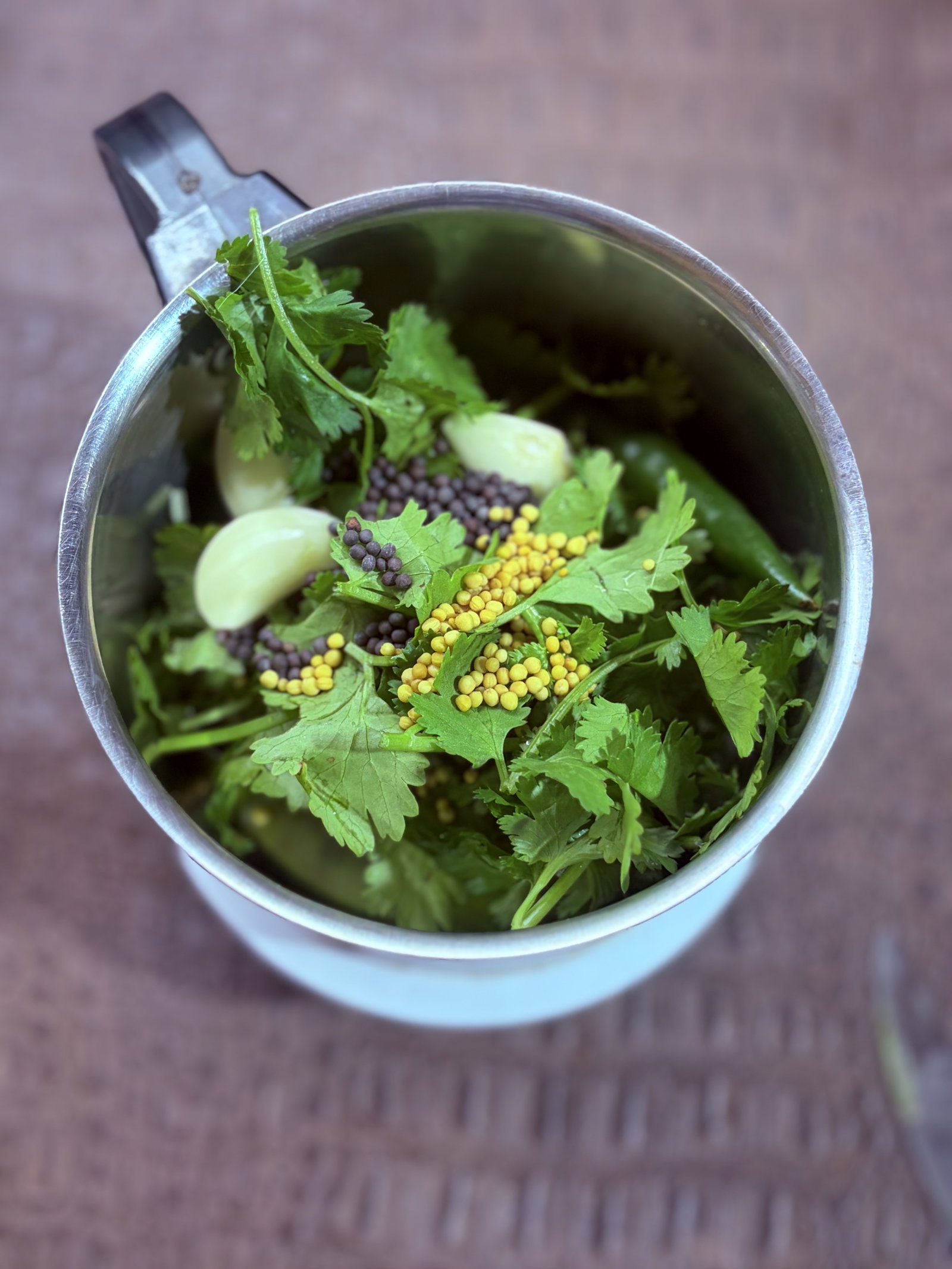 Step 1.1: In a grinder, combine fresh coriander, garlic cloves, green chilli, black mustard seeds, and yellow mustard seeds