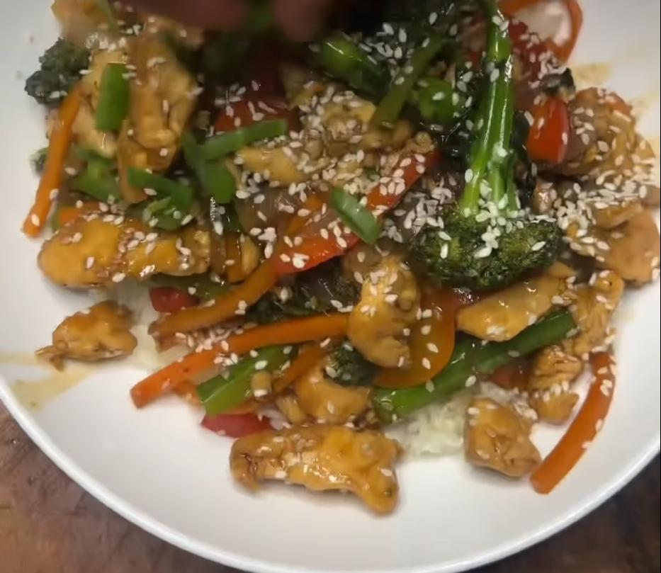 Step 1.1: Serve the stir fry over cooked rice and garnish with sesame seeds, sliced spring onion, and a pinch of chili flakes