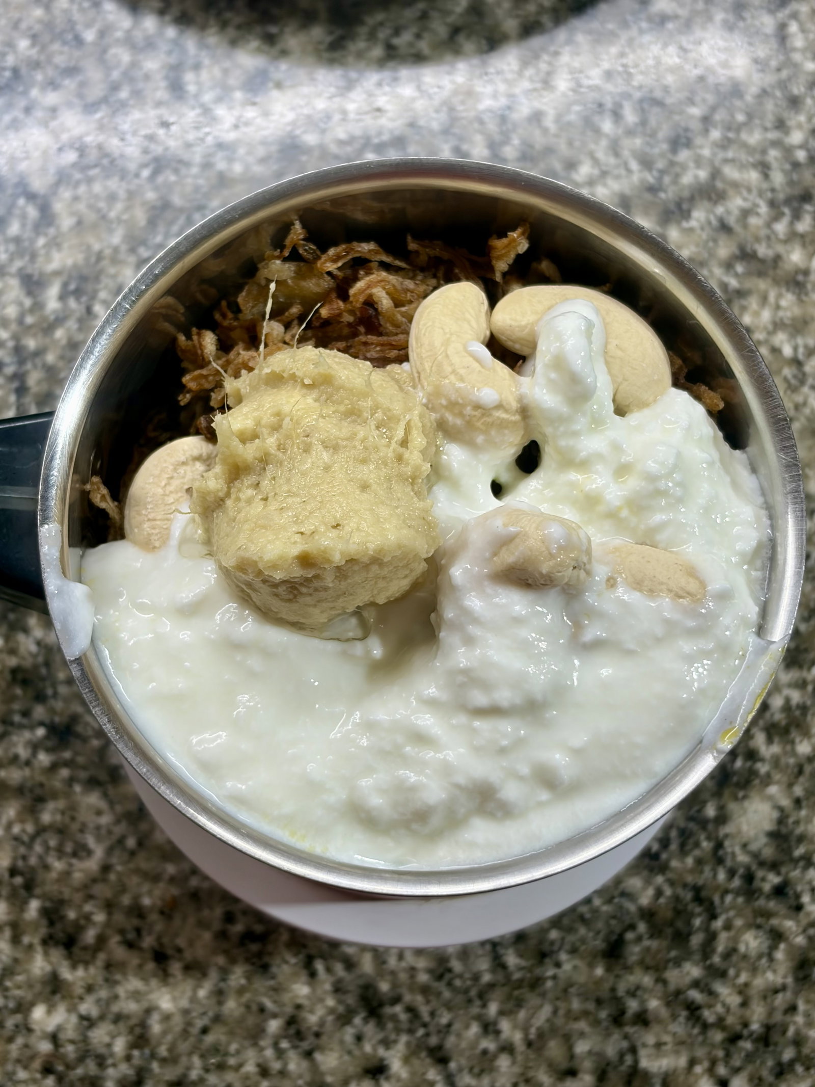 Step 1.1: In a grinder, combine the fried onions, cashews, yogurt, and ginger-garlic paste
