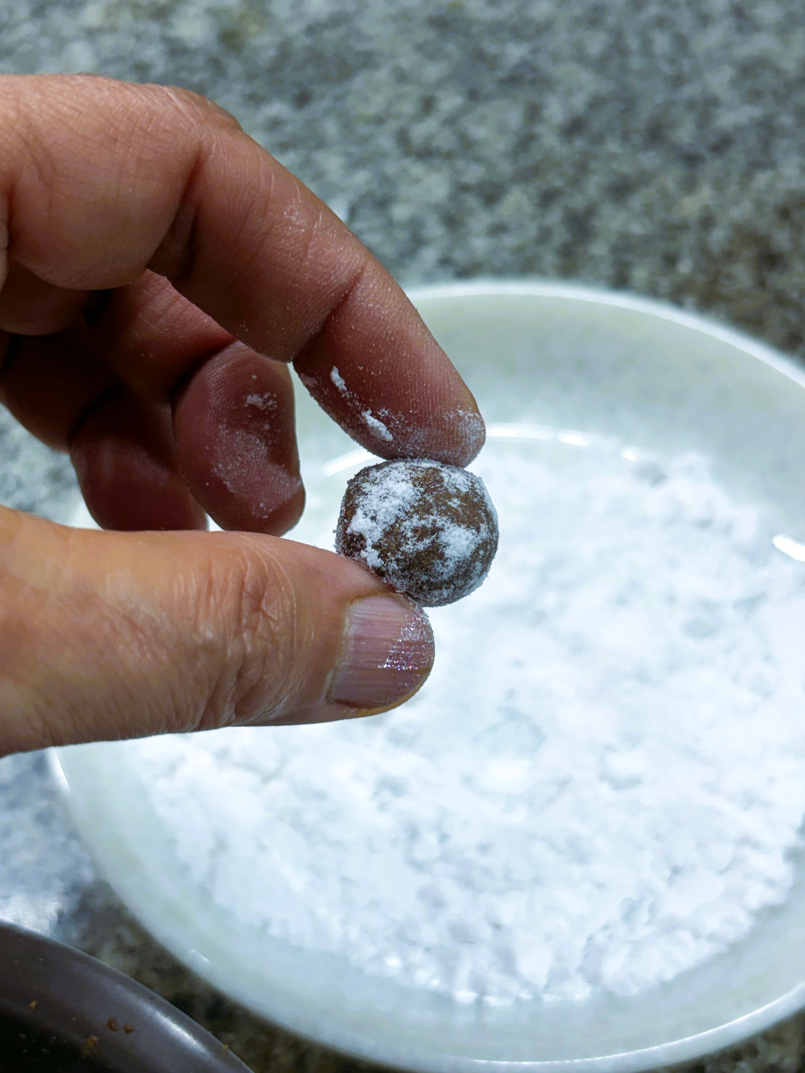 Step 4.1: Immediately roll each ball in extra powdered sugar until evenly coated, and place them on a clean, dry plate