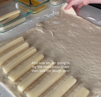 Step 1.1: Place the mozzarella sticks on one end of the dough