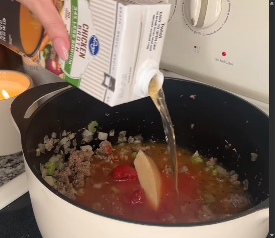 Step 1.1: Mix in flour, tomato paste, tomato sauce, Parmesan rind, and chicken broth, and bring to a boil
