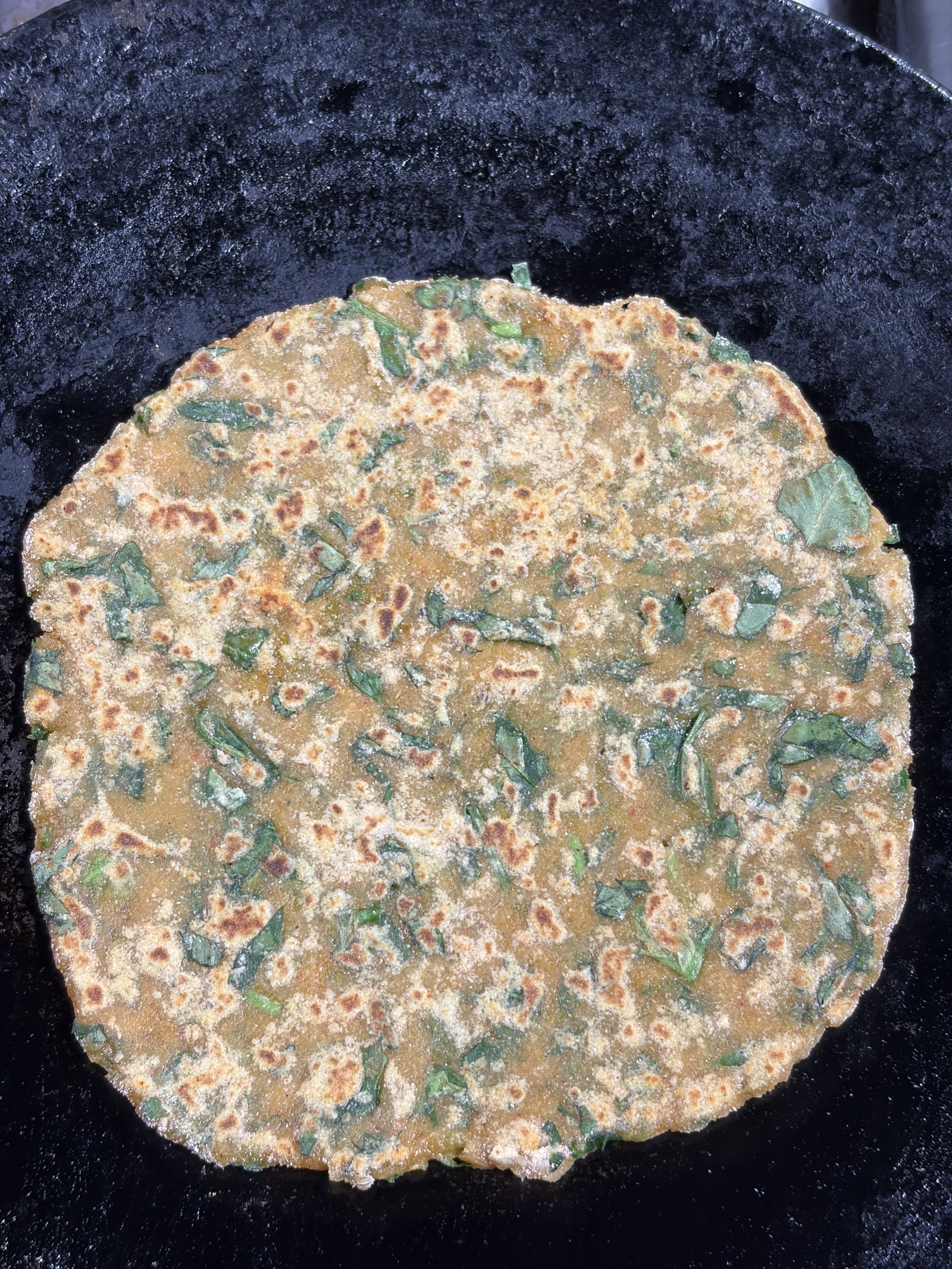 Step 3.1: पराठा गरम तवे पर रखें और हल्के भूरे धब्बे आने तक पकाएं।