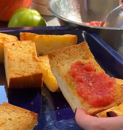 Step 1.1: Grate the ripe tomatoes and spread them evenly over the garlic bread slices