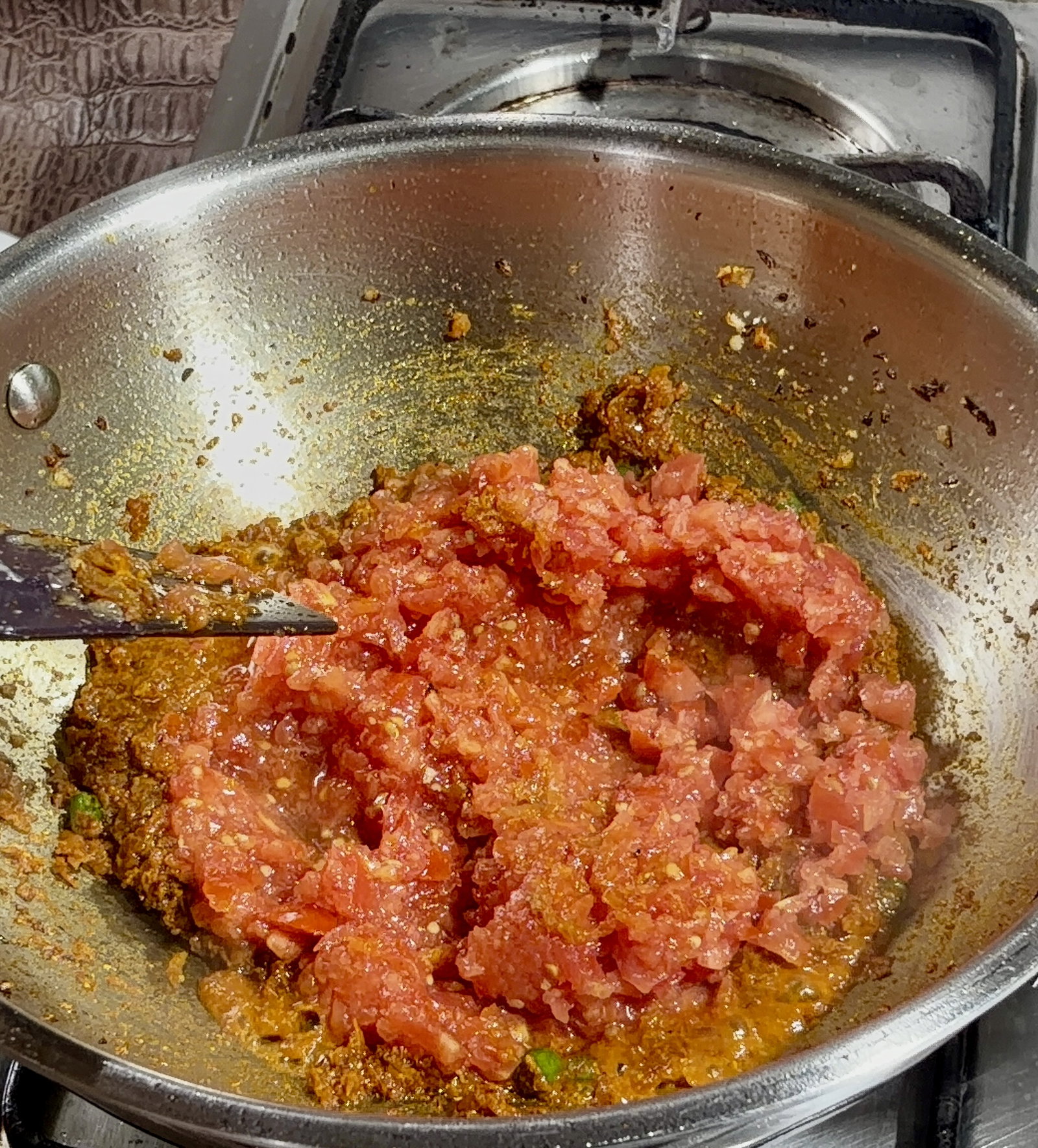 Step 2.1: Add chopped tomatoes and cook over medium-high heat until soft and mushy, and the oil begins to separate from the sides of the masala