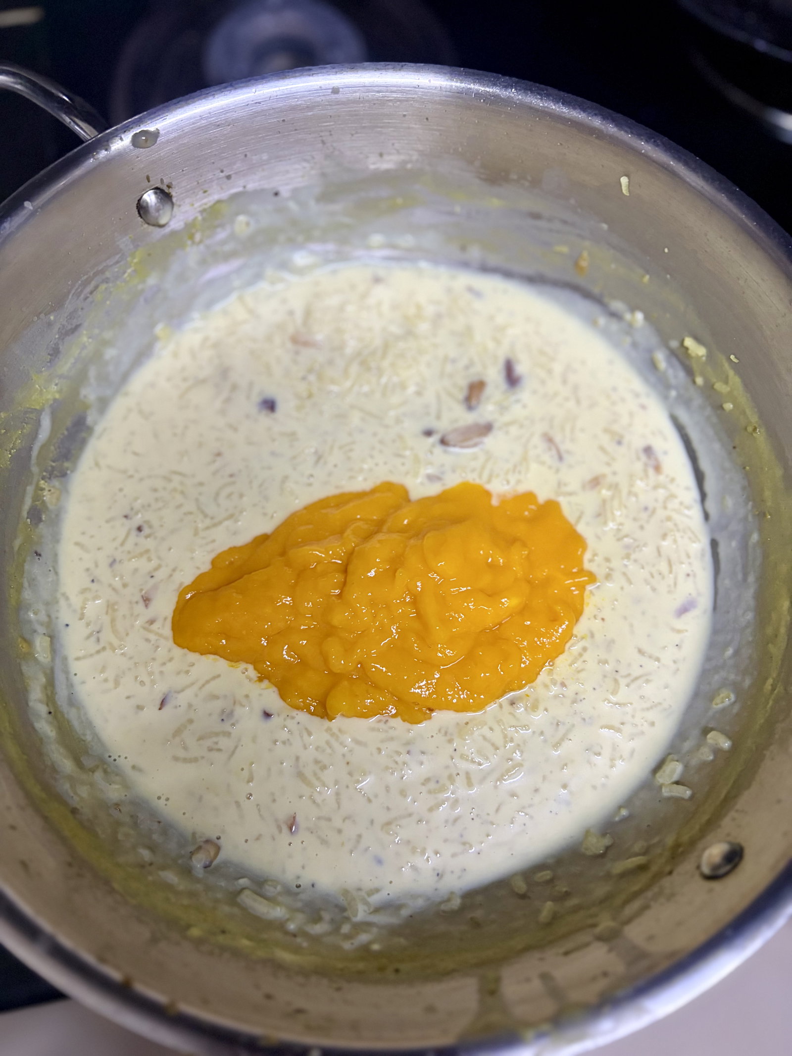 Step 7.1: Once cooled, gently fold in the mango puree and fresh mango chunks
