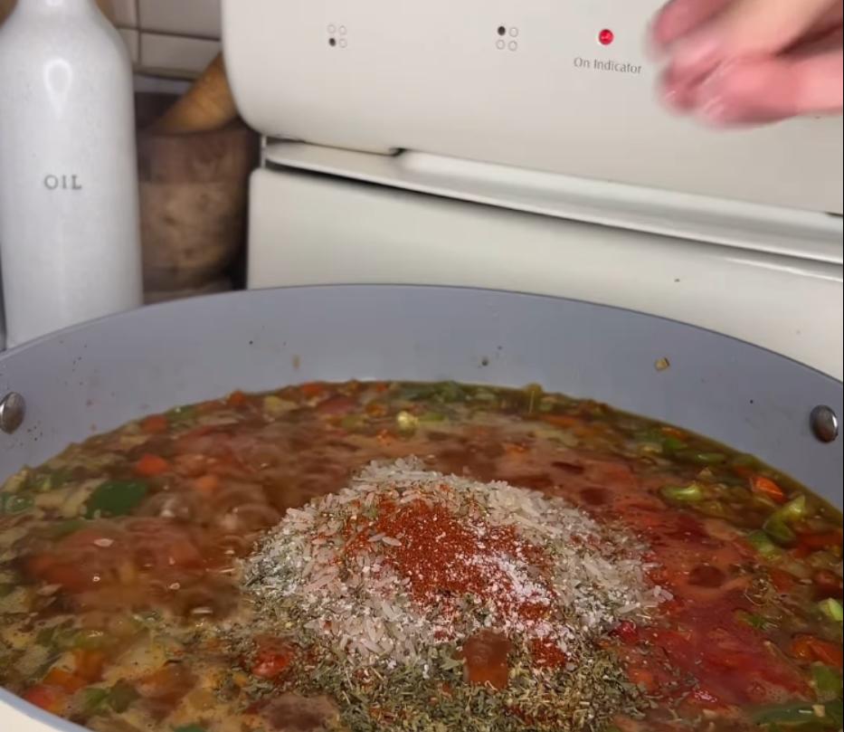 Step 1.1: Add diced tomatoes, rice, oregano, paprika, salt, pepper, cooked Italian sausage, and bay leaves to the pan