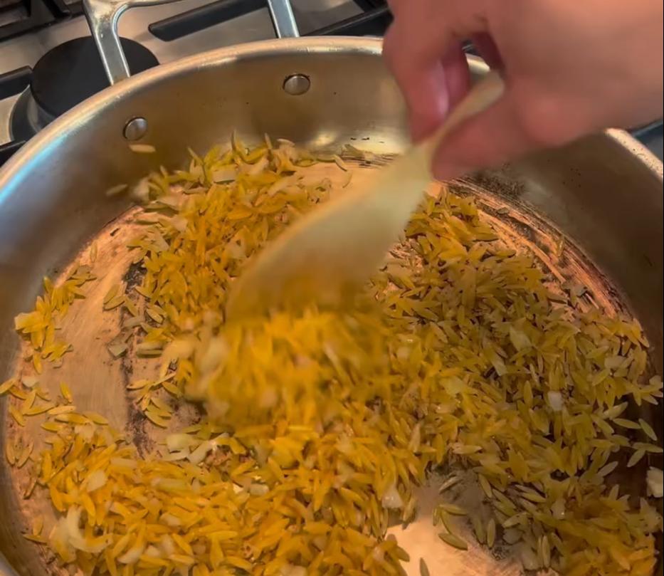 Step 2.1: Add orzo to the pan and toast briefly, then gradually add chicken stock, simmering and stirring until orzo is tender and creamy
