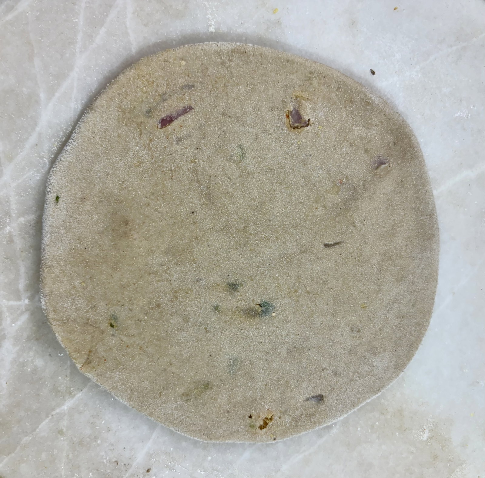 Step 3.1: Dust with dry flour and, using a rolling pin, gently roll into a round paratha of even thickness without applying too much pressure
