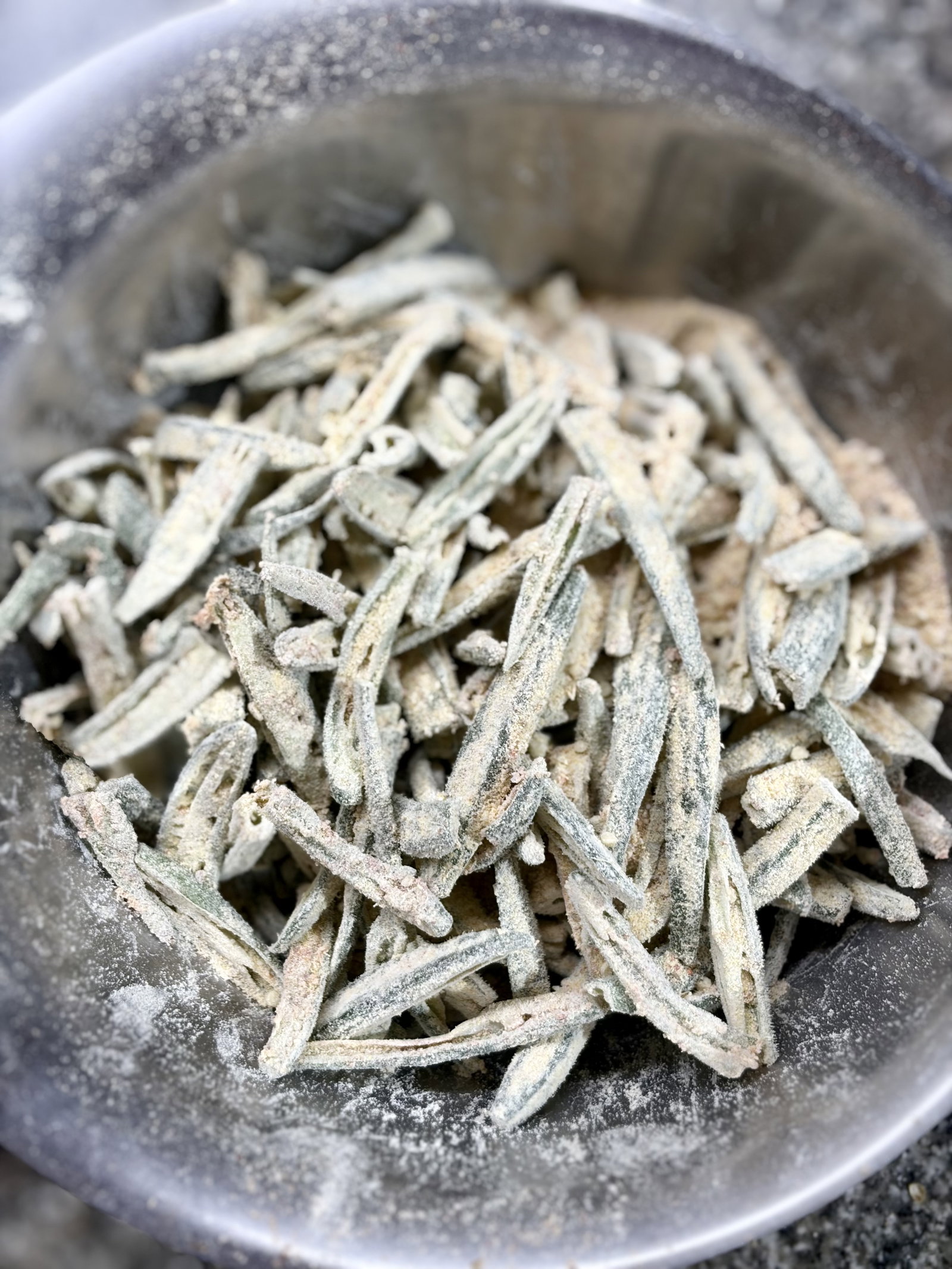 Step 3.1: Just before frying, sprinkle the rice flour and gram flour (besan) over the okra