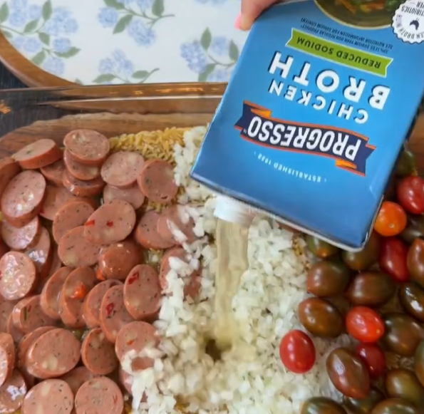 Step 1.1: Pour chicken broth and pasta sauce over everything so the orzo is mostly submerged