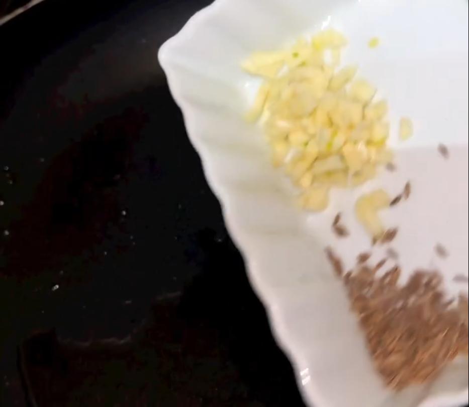 Step 4.1: Remove the oil from the pan and shallow fry garlic cloves, green chillies, cumin, red dried chilli, and curry leaves for 3 minutes until fragrant