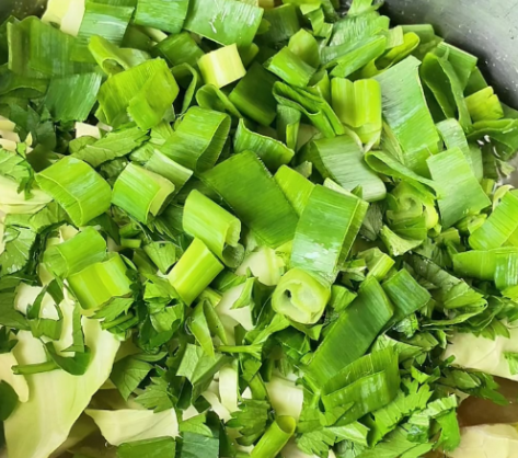 Step 4.1: Add cabbage, green onions, and celery to the soup as final touches