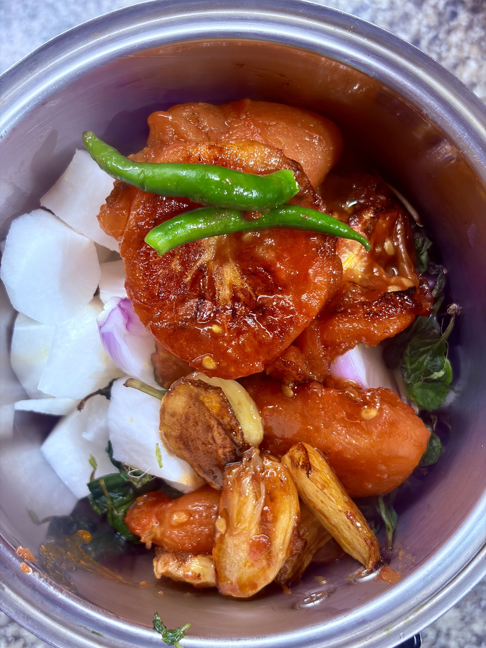 Step 1.1: In a grinder jar, add chopped radish, onion, mint leaves, green chillies, roasted tomatoes, garlic, and the remaining oil from the pan