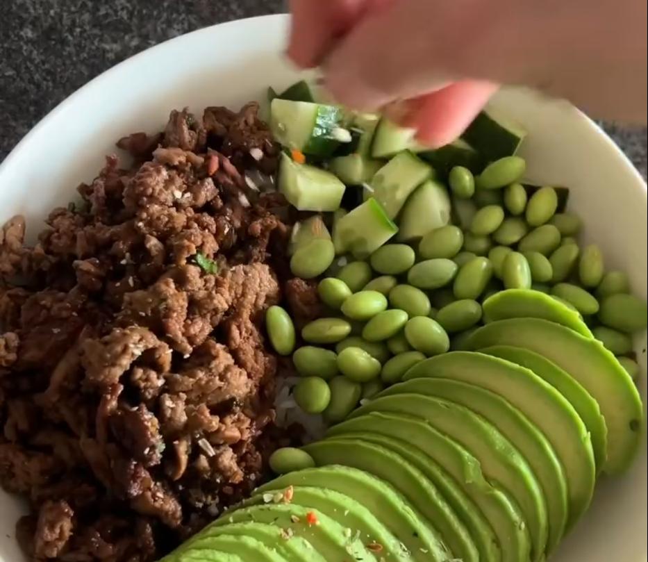 Step 1.1: Top the rice with the teriyaki beef, diced cucumber, edamame beans, and sliced avocado