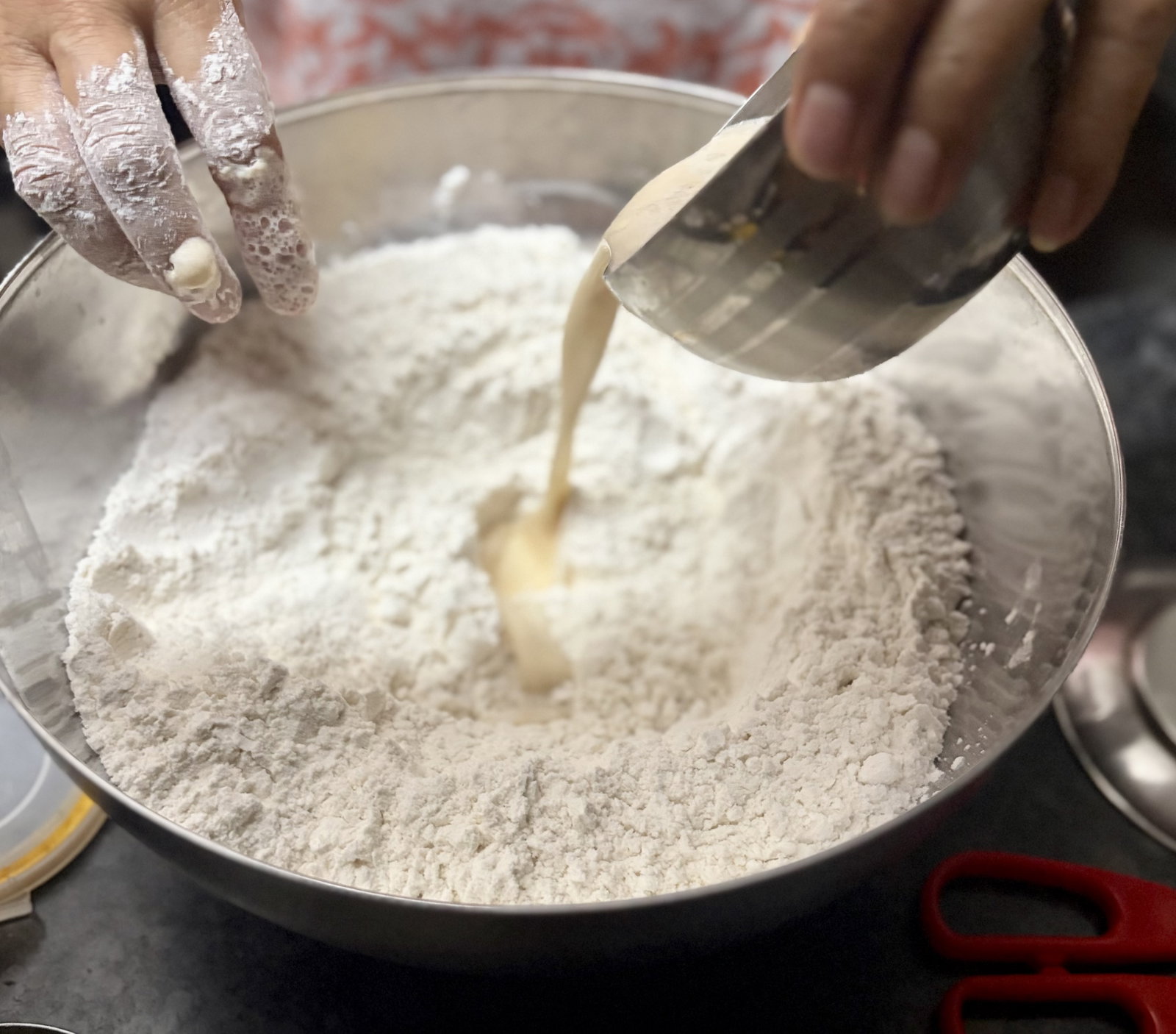 Step 2.1: Pour in the frothy yeast mixture, then gradually add the remaining lukewarm water to form a soft, sticky dough