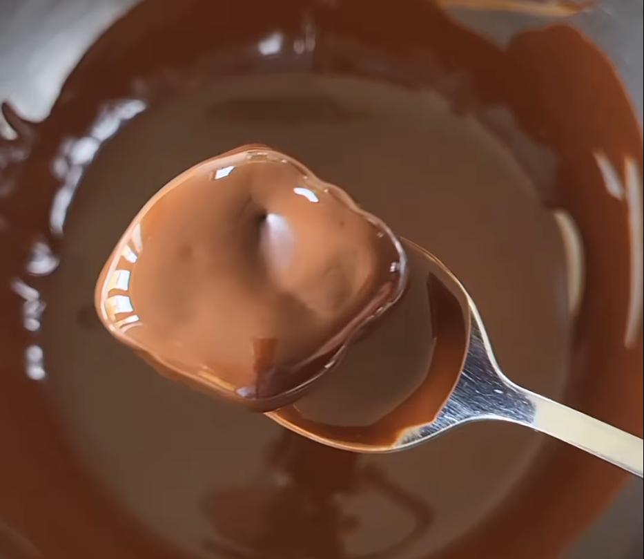 Step 1.1: Dip the frozen mango pieces in the chocolate mixture until fully coated