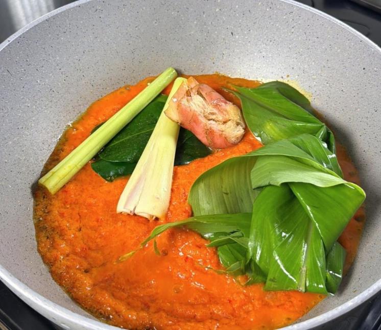 Step 3.1: Saute the spice paste with lemongrass, galangal, lime leaves, and turmeric leaf until fragrant