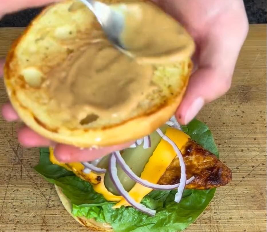 Step 1.1: Build the burger with lettuce, red onion, the cheesy grilled chicken and dill pickles, then top with the bun lid and serve