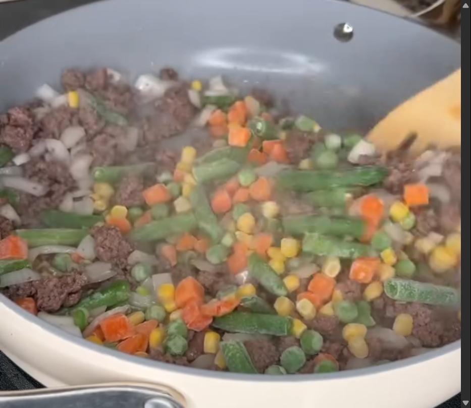 Step 2.1: Mix in diced onion, frozen mixed veggies, and garlic, and sauté until soft and fragrant