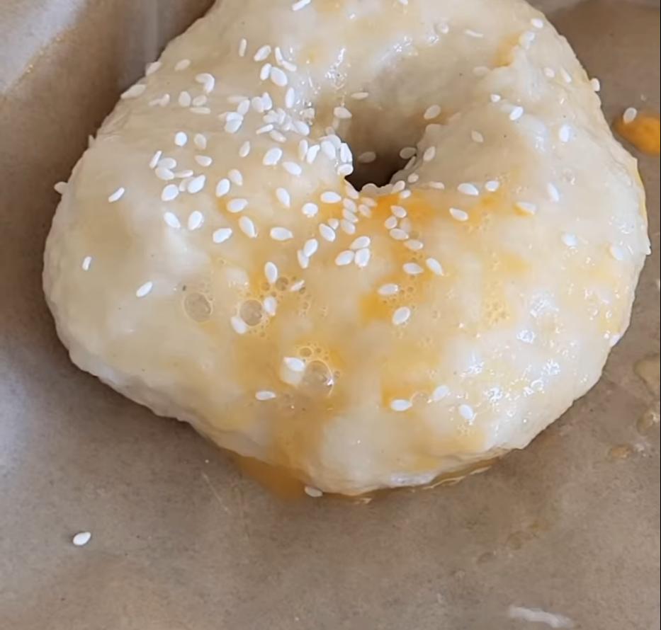 Step 1.1: Transfer to a lined baking tray, brush with egg wash and sprinkle with sesame seeds