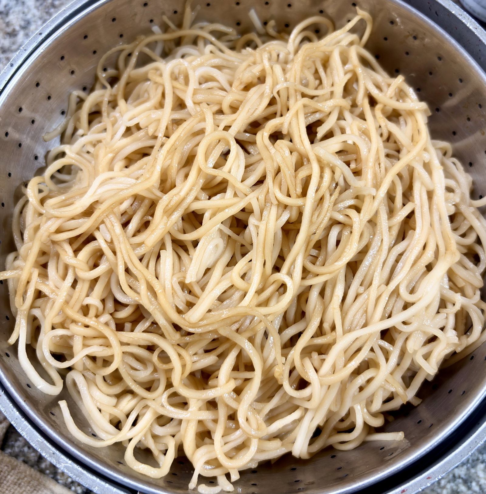 Step 2.1: Drizzle 1 tbsp of soy sauce and 1 tbsp of oil over the noodles