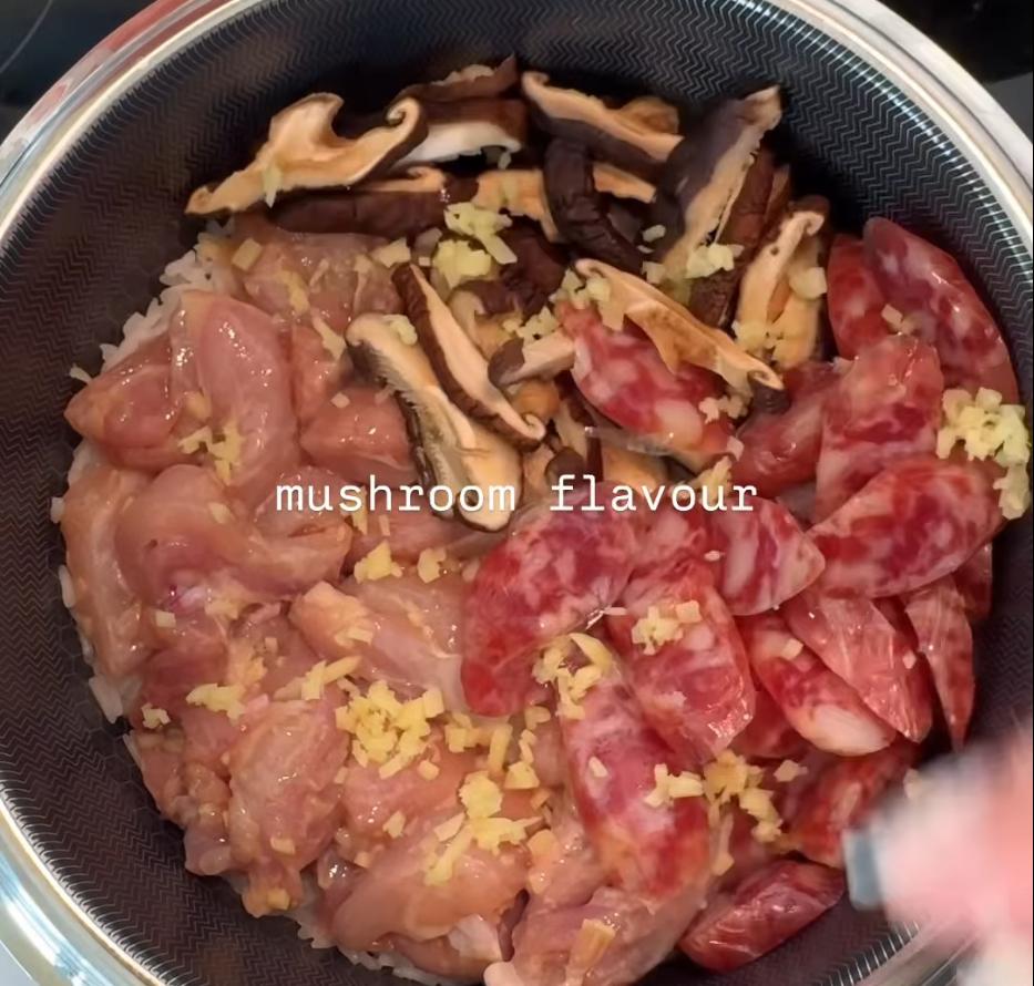 Step 1.1: Reduce the heat to low and add the marinated chicken, mushrooms, and sausage on top of the rice