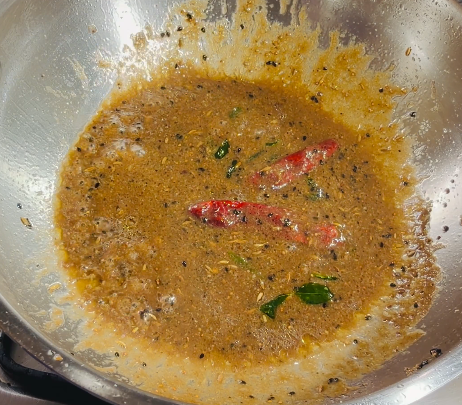 Step 3.2: Pour in the strained tamarind pulp and stir well for a few seconds