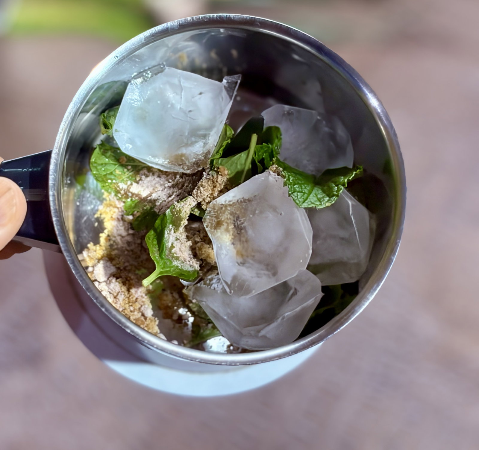 Step 2.1: ब्लेंडर में पुदीने की पत्तियां, गुड़ (यदि उपयोग कर रहे हैं), काली मिर्च पाउडर, काला नमक और बर्फ के टुकड़े डालें। इसे चिकना पेस्ट बना लें।