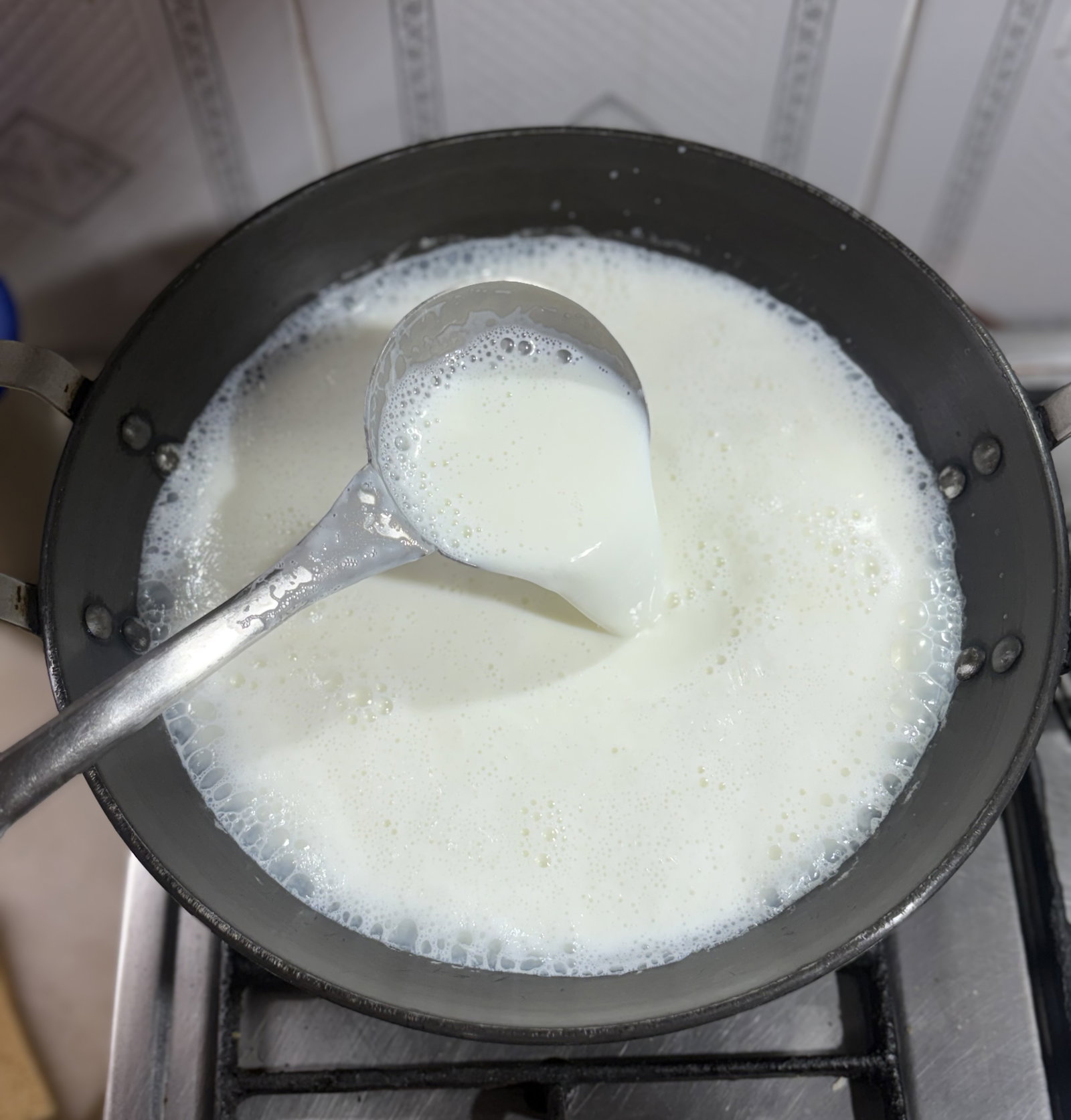 Step 1.1: Add a splash of water to a heavy-bottomed pan to prevent sticking, then pour in the milk