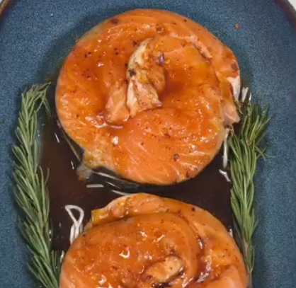 Step 2.1: Pour the marinade over the salmon and place two rosemary leaves in the baking pan with the salmon