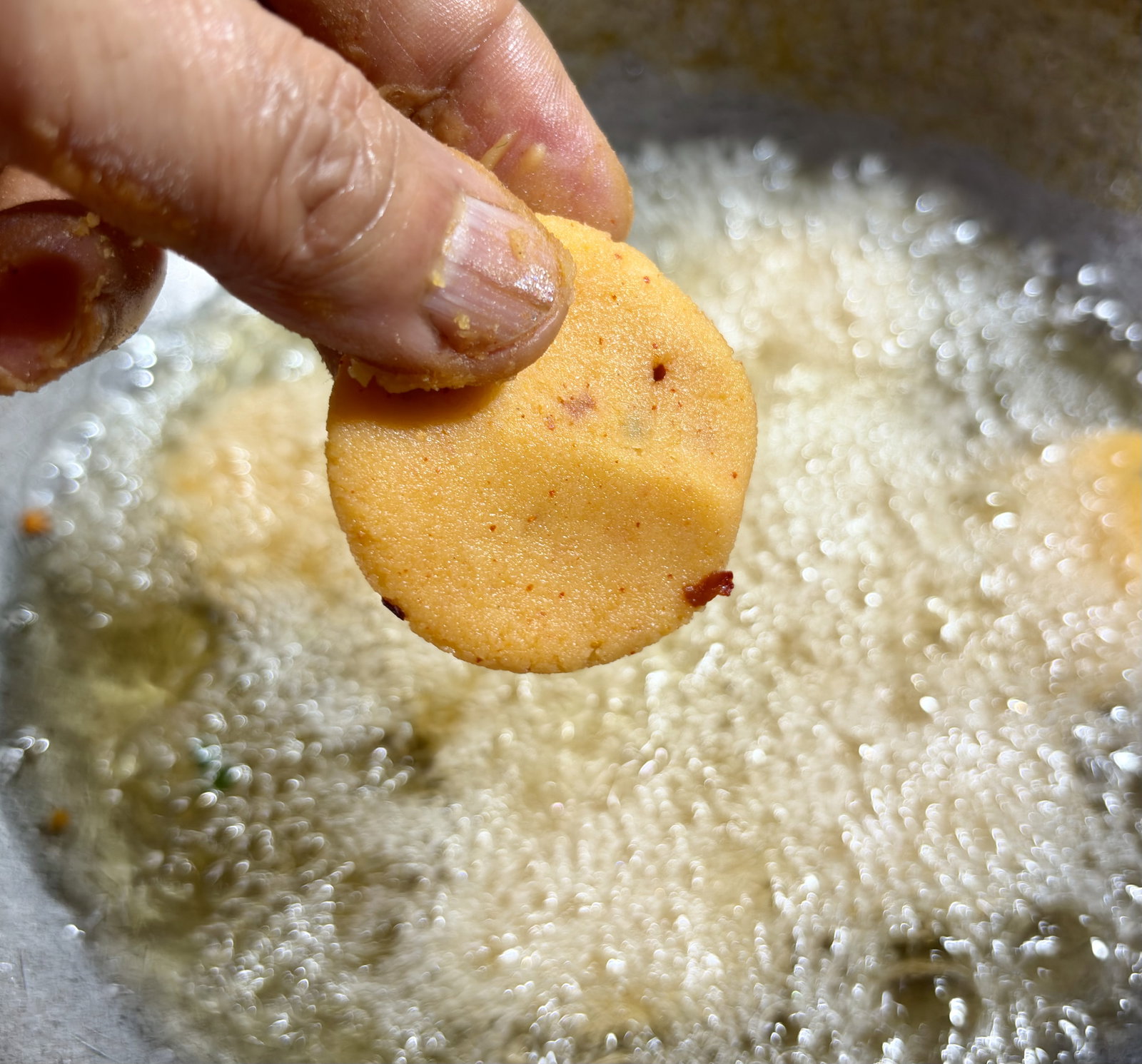Step 4.1: Slide the mathris into the hot oil in batches, making sure not to overcrowd the pan