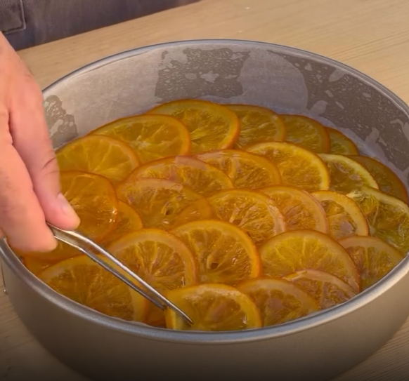 Step 3.1: Arrange the cooked oranges in a 25cm round pan and press lightly