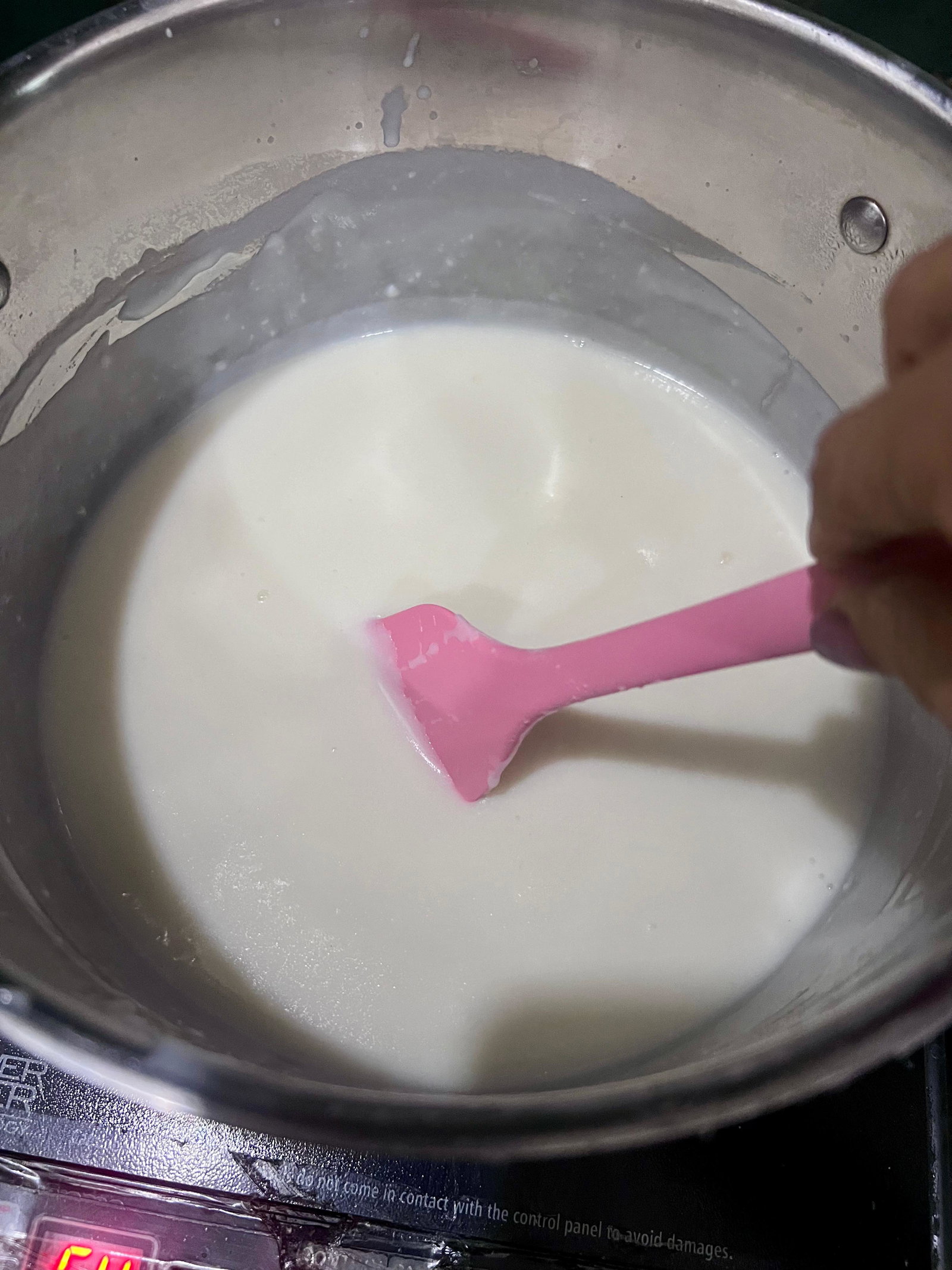 Step 1.2: Once the milk boils, lower the heat and slowly add the slurry, stirring continuously