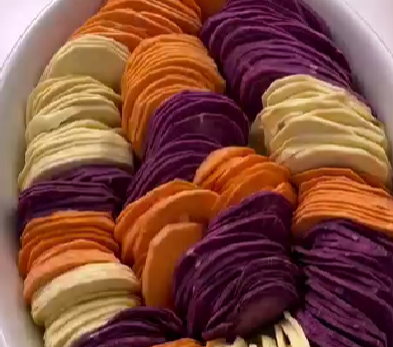 Step 3.1: In a baking dish, arrange the potato slices in alternating colors — orange, purple, white — for a beautiful Thanksgiving ombré effect