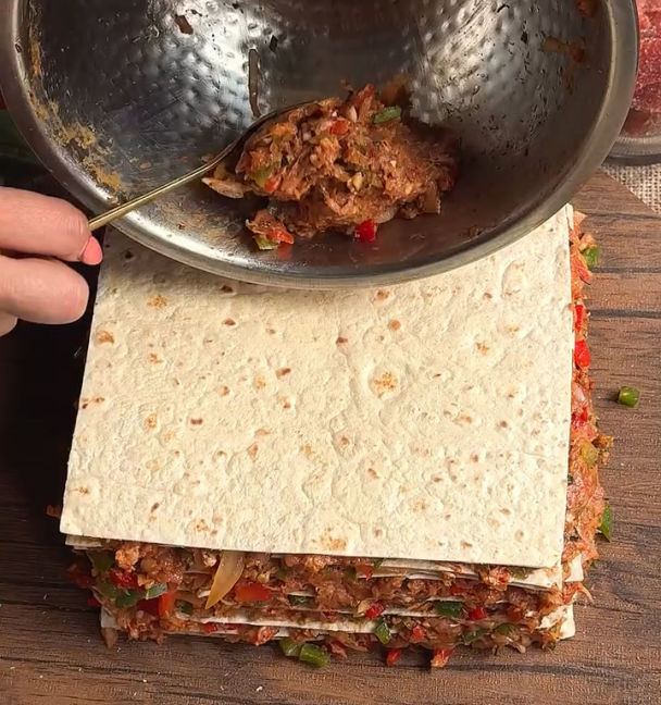 Step 1.1: Take one tortilla, spread a thin layer of the mince mixture, and place another tortilla on top
