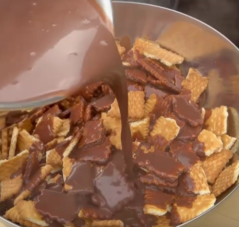 Step 1.1: Pour the chocolate sauce over the biscuits and gently fold with a spatula until fully coated