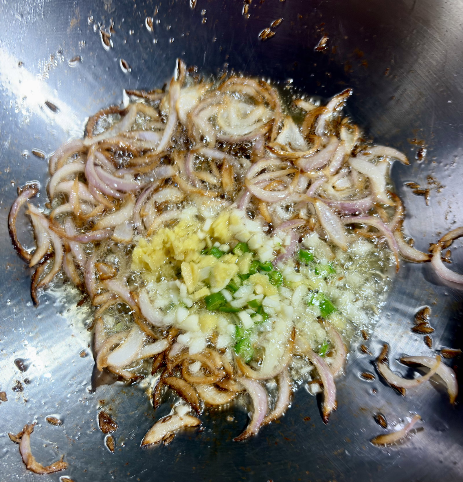 Step 2.1: Stir in the chopped ginger, garlic, and green chilli, cooking for 1–2 minutes until the raw aroma disappears
