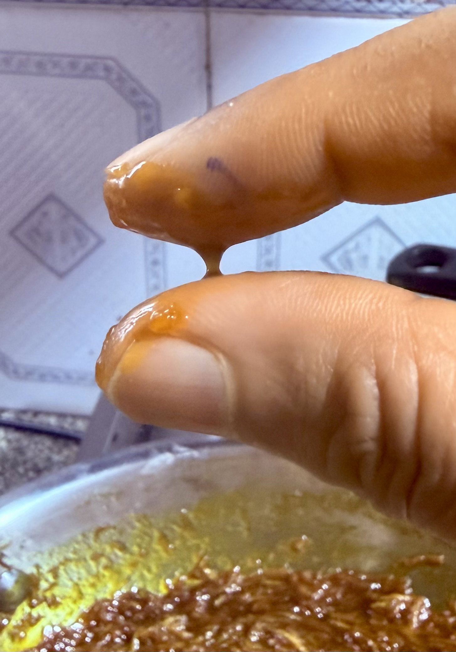 Step 4.2: Cool a drop of syrup, then press it between your thumb and forefinger—it should form a single, unbroken thread when pulled apart
