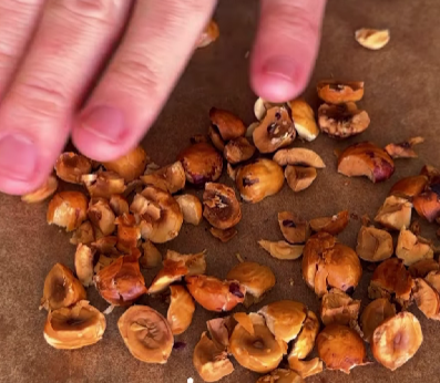 Step 4.1: Remove the skins, then roughly crush the nuts using the bottom of a heavy pan