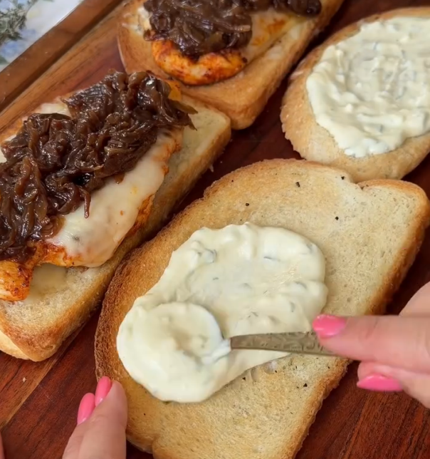 Step 1.1: Spread aioli on the toasted bread, add the chicken, pile on the caramelized onions, and serve with hot au jus for dipping