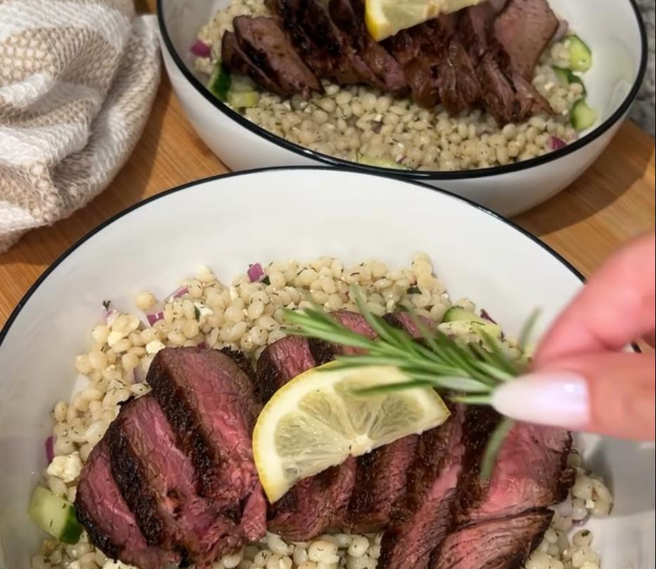 Step 3.1: Serve sliced steaks over top of couscous and garnish with a lemon wedge and rosemary sprig