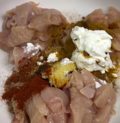 Step 1.1: Mix chicken, garlic, smoked paprika, cumin, coriander, cardamom, turmeric, cloves, ginger, salt, pepper, yogurt, and olive oil in a bowl