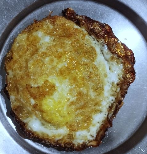 Step 1.2: When the oil becomes hot, crack open one egg and fry until the edges become crispy