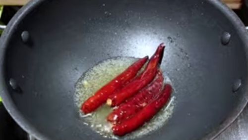 Step 1.1: Add dried red chilli to the same oil and roast it for 1 minute