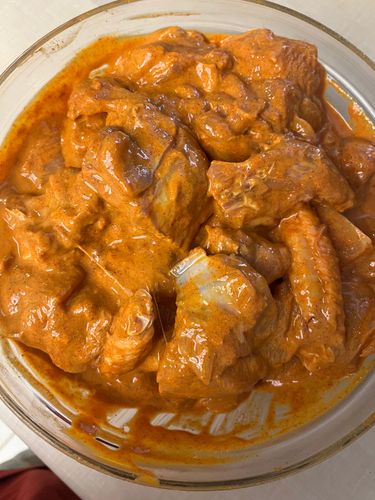 Step 1.4: Transfer the chicken pieces to a mixing bowl and add salt, red chilli powder, coriander powder, cumin powder, and thick curd
