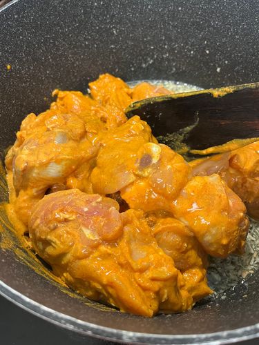 Step 3.1: Add the marinated chicken pieces and deep fry on medium flame, stirring occasionally until all the moisture evaporates and oil separates from the chicken