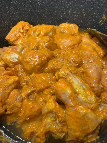 Step 3.2: Add the marinated chicken pieces and deep fry on medium flame, stirring occasionally until all the moisture evaporates and oil separates from the chicken