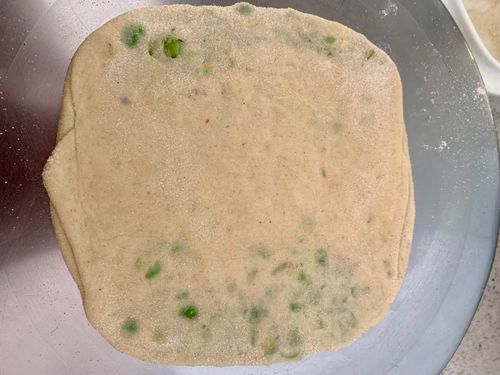 Step 3.1: Dust with flour and gently roll it out into a thick paratha