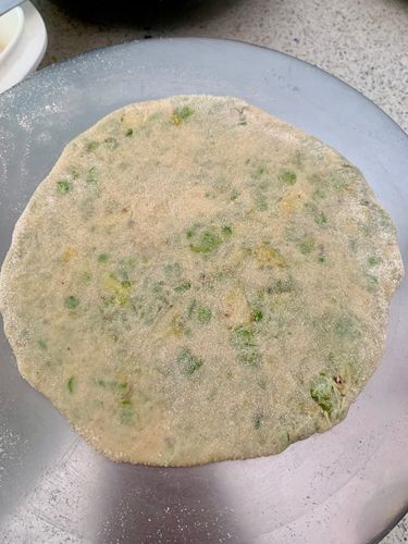 Step 3.2: Dust with flour and gently roll it out into a thick paratha